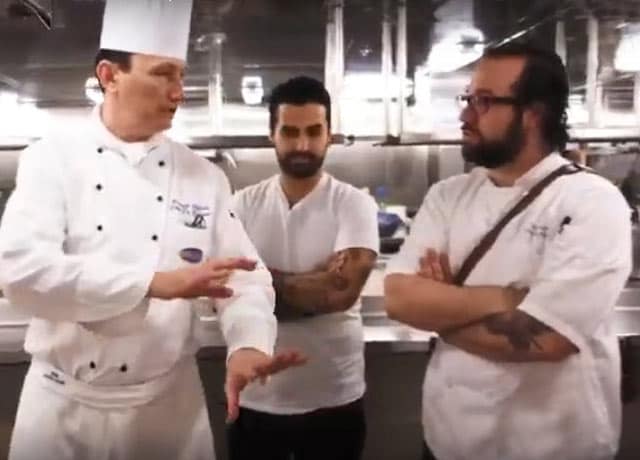2 chefs talking in the kitchen of a princess cruise ship